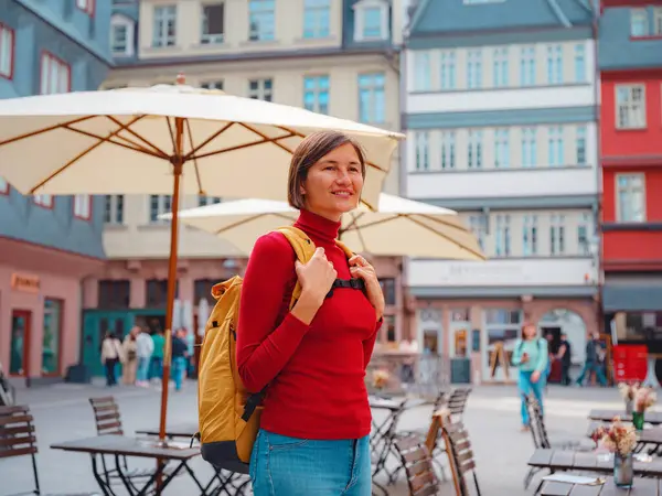 Turist kadın, tarihi caddelerini, güzel mimarisini ve kültürel yapısını keşfetmek için eski Frankfurt kasabasında geziniyor..