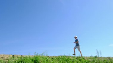 Tarlalar ve ormanlarla çevrili kırsal toprak yolda yürüyen bir adam kırsal hayatın huzurlu ve kırsal atmosferini yakalıyor. Yalnızlığı ve doğayı vurgulayan basit, sessiz bir sahne..