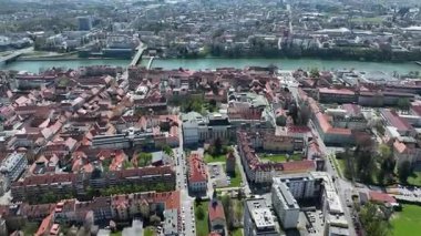 Slovenya, Maribor 'un güneşli bahar günündeki hava görüntüleri. Çatılar, şehir sokakları, tarihi binalar çiçek açan ağaçlar ve yeşil alanlarla çevrili, mükemmel bir kültür ve doğa karışımı sunuyorlar.