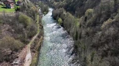 Korana Nehri 'nin insansız hava aracı manzarası Slunj yakınlarındaki engebeli arazide dönüyor. Ağaçlar kıştan dolayı hala çıplakken, berrak su ve yosunlu bankalar yaklaşan baharı ima ediyorlar. Hırvat doğası.