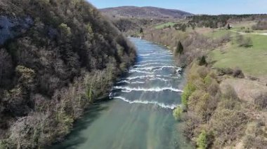 Korana Nehri 'nin insansız hava aracı manzarası Slunj yakınlarındaki engebeli arazide dönüyor. Ağaçlar kıştan dolayı hala çıplakken, berrak su ve yosunlu bankalar yaklaşan baharı ima ediyorlar. Hırvat doğası.