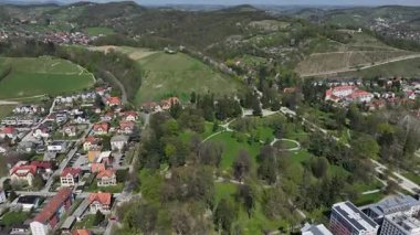 Slovenya, Maribor 'un güneşli bahar günündeki hava görüntüleri. Çatılar, şehir sokakları, tarihi binalar çiçek açan ağaçlar ve yeşil alanlarla çevrili, mükemmel bir kültür ve doğa karışımı sunuyorlar.