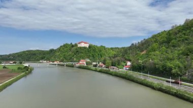 Tarihsel Rajhenburg Şatosu yukarıdan yemyeşil bahar ortamından izlendi. Ortaçağ mimarisi, Sloven kırsalını çevreleyen panoramik manzaralı tepenin üzerinde yer alıyor. Sava Nehri