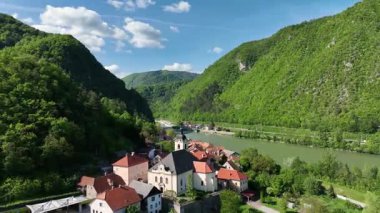 İlkbaharda Slovenya manzaralarının havadan görünüşü. Savinja nehri kıyısında küçük bir Slovenya kasabası. Yeşil tepeler ve ormanlarla çevrili, ılık Mayıs güneşinde havadan gösterilen.