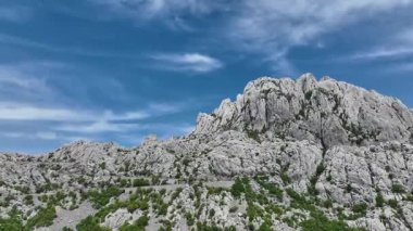 Tulove Grede kayalık tepeleri ilkbahar güneşinde tepeden. İnsansız hava aracı Hırvatistan 'daki Tulove Grede' in engebeli kireçtaşı zirvelerinde uçarak dramatik uçurumları ve panoramik manzaralı vahşi bahar doğasını gözler önüne seriyor.