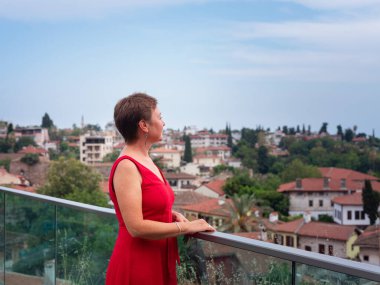 Sıcak yaz akşamları Antalya 'nın dar sokaklarında kırmızı elbiseli bir kadın yürüyor. Tarihsel atmosfer ve Akdeniz cazibesi barışçıl seyahat deneyimleri yaratır. Kalechi manzarası