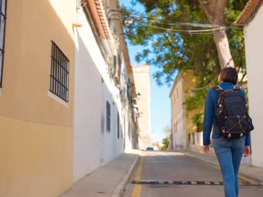 İspanya 'nın Alicante eyaletinin büyüleyici dar sokaklarında gezinen, tarihi Akdeniz mimarisi ile çevrili, barışçıl atmosfer ve kültürel ortamın tadını çıkaran genç bir kadın..
