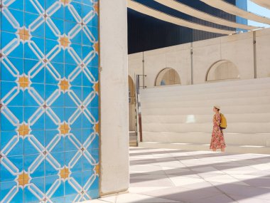 Abu Dabi 'de Qasr Al Hosn Parkı' nı keşfeden genç bir kadın. Yeşillik ve tarihi simgelerle çevrelenmiş, kentin kalbindeki sakin atmosfer ve Emirati mirasının tadını çıkarıyor..