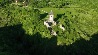 Korana yakınlarındaki yeşil tepede Ortaçağ Dreznik Grad 'ı. Yukarıdan görülen Dreznik Eski Kasabası 'nın tarihi kalıntıları Korana Nehri yakınlarındaki yemyeşil tepelere kurulmuştu. Huzurlu ve sinematik bahar manzarası