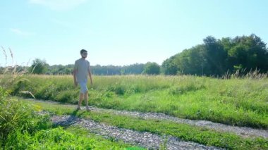 Tarlalar ve ormanlarla çevrili kırsal toprak yolda yürüyen bir adam kırsal hayatın huzurlu ve kırsal atmosferini yakalıyor. Yalnızlığı ve doğayı vurgulayan basit, sessiz bir sahne..