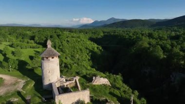 Korana yakınlarındaki yeşil tepede Ortaçağ Dreznik Grad 'ı. Yukarıdan görülen Dreznik Eski Kasabası 'nın tarihi kalıntıları Korana Nehri yakınlarındaki yemyeşil tepelere kurulmuştu. Huzurlu ve sinematik bahar manzarası