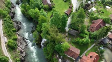 Slunj ve Korana nehirlerindeki Rastoke su değirmeni köyü. Şelaleleri, ahşap evleri, nehirleri akan sevimli Rastoke köyü. Hırvatistan 'ın göbeğindeki peri masalı bahar mevkiinin havadan görünüşü