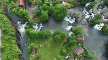 Slunj ve Korana nehirlerindeki Rastoke su değirmeni köyü. Şelaleleri, ahşap evleri, nehirleri akan sevimli Rastoke köyü. Hırvatistan 'ın göbeğindeki peri masalı bahar mevkiinin havadan görünüşü
