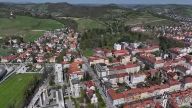 Slovenya, Maribor 'un güneşli bahar günündeki hava görüntüleri. Çatılar, şehir sokakları, tarihi binalar çiçek açan ağaçlar ve yeşil alanlarla çevrili, mükemmel bir kültür ve doğa karışımı sunuyorlar.