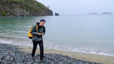 Genç adam bulutlu gökyüzünün altında Türk denizi yakınlarında tek başına. Dalgın ruh hali, soğuk esinti, dalgaların çarpması. Doğayı yansıtmak ve birbirine bağlamak için huzurlu bir zaman..