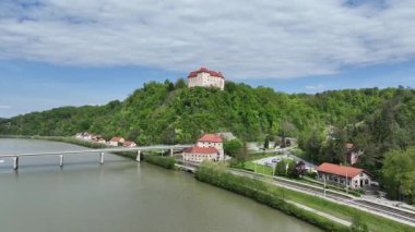Tarihsel Rajhenburg Şatosu yukarıdan yemyeşil bahar ortamından izlendi. Ortaçağ mimarisi, Sloven kırsalını çevreleyen panoramik manzaralı tepenin üzerinde yer alıyor. Sava Nehri