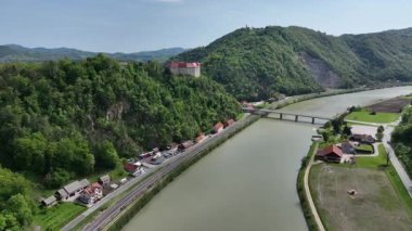 İlkbaharda Slovenya manzaralarının havadan görünüşü. Tarihsel Rajhenburg Şatosu yukarıdan yemyeşil bahar ortamından izlendi. Ortaçağ mimarisi panoramik manzaralı tepenin üstünde duruyor.