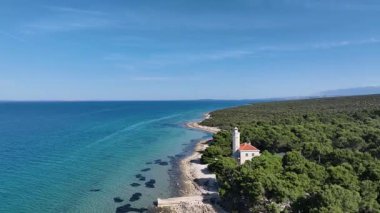 Güneşli bir günde Vir Adası 'ndaki deniz feneri. Otok Vir 'de minimalist deniz feneri görüntüsü. Yumuşak ışık, gölgeler ve sakin deniz havası hikaye anlatmak ve seyahat etmek için mükemmel..