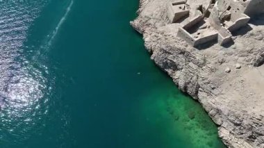 Pag Adası 'nın insansız hava aracı görüntüleri kayalık arazi, turkuaz deniz, dolambaçlı yollar ve kıyı köylerini gösteriyor. Mayıs başlarında yeşil tepeler, güneşli kıyılar ve açık Adriyatik manzaralı.