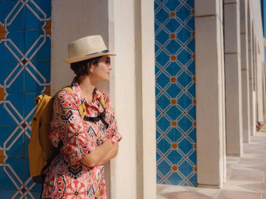 Abu Dabi 'de Qasr Al Hosn Parkı' nı keşfeden genç bir kadın. Yeşillik ve tarihi simgelerle çevrelenmiş, kentin kalbindeki sakin atmosfer ve Emirati mirasının tadını çıkarıyor..