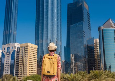 Abu Dabi 'de Qasr Al Hosn Parkı' nı keşfeden genç bir kadın. Yeşillik ve tarihi simgelerle çevrelenmiş, kentin kalbindeki sakin atmosfer ve Emirati mirasının tadını çıkarıyor..