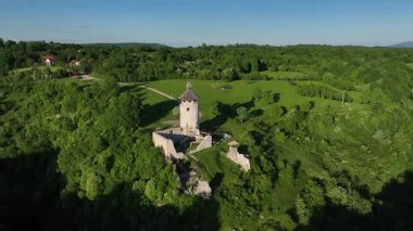 Korana yakınlarındaki yeşil tepede Ortaçağ Dreznik Grad 'ı. Yukarıdan görülen Dreznik Eski Kasabası 'nın tarihi kalıntıları Korana Nehri yakınlarındaki yemyeşil tepelere kurulmuştu. Huzurlu ve sinematik bahar manzarası