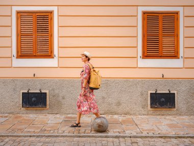 Varazdin sokaklarında yaz günü eski, tarihi şehir merkezinde yürüyen güzel bir kadın. Bu güzel caddeleri keşfeden turist, Hırvat kentinin rahat ve kültürel havasını yaşıyor..