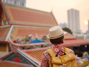 Bangkok 'taki Budist Tapınakları' nın yakınlarındaki Renkli Sokakları Keşfeden Kadın. Geleneksel mimari ve güzel Budist tapınaklarıyla çevrili Bangkok 'un büyüleyici sokaklarında gezen kadın gezgin..