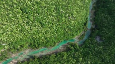 Korana nehri Plitvice yakınlarındaki yeşil tepelerden akar. Korana Nehri 'nin tepeler ve ormanlar boyunca kıvrımlı manzarası. Sıcak güneş ışığı ve Hırvat kırsalının zengin dokularına sahip taze bahar manzarası