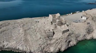 Pag Adası 'nın insansız hava aracı görüntüleri kayalık arazi, turkuaz deniz, dolambaçlı yollar ve kıyı köylerini gösteriyor. Mayıs başlarında yeşil tepeler, güneşli kıyılar ve açık Adriyatik manzaralı.