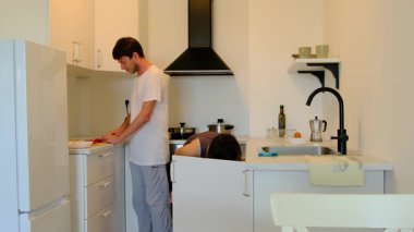 Genç çift, güzel ve rahat bir mutfakta ev yapımı öğle yemeği hazırlıyor. Sebze doğrarlar, yemek karıştırırlar, gülerler ve yan yana yemek pişirmenin basit zevkini çıkarırlar. Paylaşılan işler bağlantı ve bakıma dönüşür.