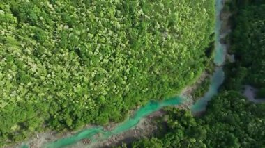 Korana nehri Plitvice yakınlarındaki yeşil tepelerden akar. Korana Nehri 'nin tepeler ve ormanlar boyunca kıvrımlı manzarası. Sıcak güneş ışığı ve Hırvat kırsalının zengin dokularına sahip taze bahar manzarası