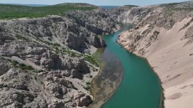 Obrovac 'tan nehir ağzı antenine kadar Zrmanja kanyonu nehri. Dolambaçlı Zrmanja nehrinin havadan çekimleri derin kanyonu, bereketli bahar renklerini ve uzak yolları kesiyor.