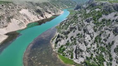 Obrovac 'tan nehir ağzı antenine kadar Zrmanja kanyonu nehri. Dolambaçlı Zrmanja nehrinin havadan çekimleri derin kanyonu, bereketli bahar renklerini ve uzak yolları kesiyor.