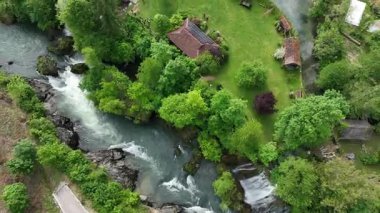 Slunj ve Korana nehirlerindeki Rastoke su değirmeni köyü. Şelaleleri, ahşap evleri, nehirleri akan sevimli Rastoke köyü. Hırvatistan 'ın göbeğindeki peri masalı bahar mevkiinin havadan görünüşü