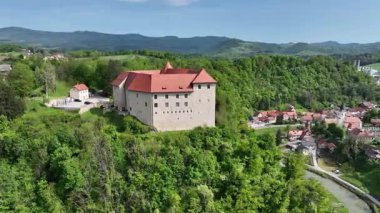 İlkbaharda Slovenya manzaralarının havadan görünüşü. Tarihsel Rajhenburg Şatosu yukarıdan yemyeşil bahar ortamından izlendi. Ortaçağ mimarisi panoramik manzaralı tepenin üstünde duruyor.