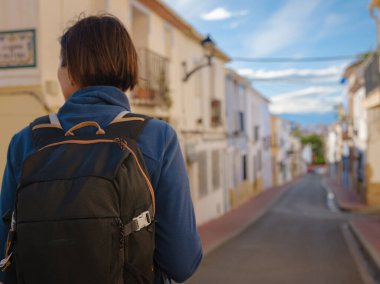 İspanya 'nın Alicante eyaletinin büyüleyici dar sokaklarında gezinen, tarihi Akdeniz mimarisi ile çevrili, barışçıl atmosfer ve kültürel ortamın tadını çıkaran genç bir kadın..