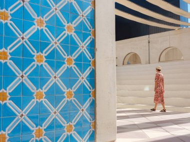 Abu Dabi 'de Qasr Al Hosn Parkı' nı keşfeden genç bir kadın. Yeşillik ve tarihi simgelerle çevrelenmiş, kentin kalbindeki sakin atmosfer ve Emirati mirasının tadını çıkarıyor..