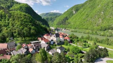 İlkbaharda Slovenya manzaralarının havadan görünüşü. Savinja nehri kıyısında küçük bir Slovenya kasabası. Yeşil tepeler ve ormanlarla çevrili, ılık Mayıs güneşinde havadan gösterilen.