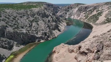 Obrovac 'tan nehir ağzı antenine kadar Zrmanja kanyonu nehri. Dolambaçlı Zrmanja nehrinin havadan çekimleri derin kanyonu, bereketli bahar renklerini ve uzak yolları kesiyor.