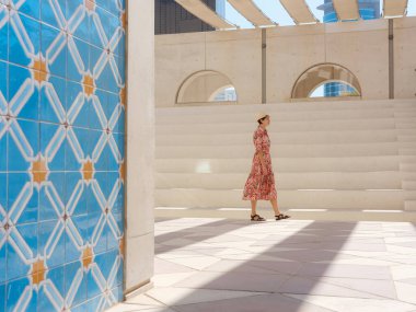 Abu Dabi 'de Qasr Al Hosn Parkı' nı keşfeden genç bir kadın. Yeşillik ve tarihi simgelerle çevrelenmiş, kentin kalbindeki sakin atmosfer ve Emirati mirasının tadını çıkarıyor..