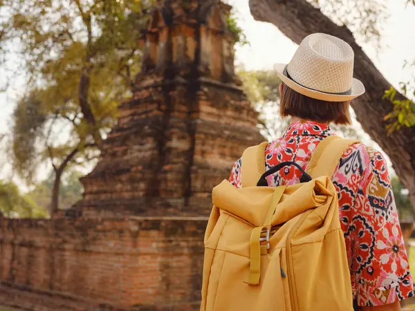 Tayland 'ın Ayutthaya kentinde tarihi parkı keşfetmek için giyinmiş genç bir bayan turist. Antik tapınaklar ve heykellerle çevrili, huzurlu bir atmosfer ve zengin kültürel mirasın tadını çıkarıyor..