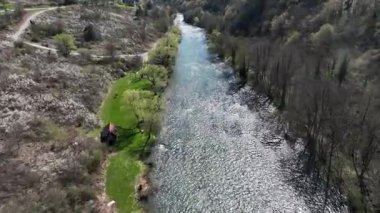Korana Nehri 'nin insansız hava aracı manzarası Slunj yakınlarındaki engebeli arazide dönüyor. Ağaçlar kıştan dolayı hala çıplakken, berrak su ve yosunlu bankalar yaklaşan baharı ima ediyorlar. Hırvat doğası.