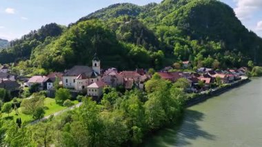 İlkbaharda Slovenya manzaralarının havadan görünüşü. Savinja nehri kıyısında küçük bir Slovenya kasabası. Yeşil tepeler ve ormanlarla çevrili, ılık Mayıs güneşinde havadan gösterilen.