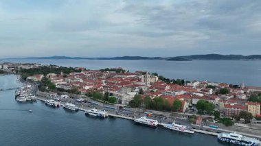 Zadar marinası ve yukarıdan görünen antik kasaba. Zadar 'ın rıhtımı, kırmızı çatıları, marinası ve Roma mirasının kıyı bahar atmosferindeki güneşli hava görüntüleri.