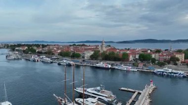 Zadar marinası ve yukarıdan görünen antik kasaba. Zadar 'ın rıhtımı, kırmızı çatıları, marinası ve Roma mirasının kıyı bahar atmosferindeki güneşli hava görüntüleri.