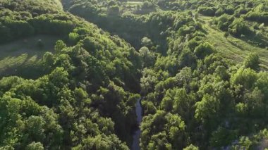 Ortaçağ Dreznik Grad yakınlarında yeşil çayırlar ve tepeler. Dreznik şehri yakınlarındaki geniş yeşil alanlar ve kırsal yolların insansız hava aracı görüntüsü. Canlı manzara, bahar büyümesi, Hırvat köylerinde tipik bir barış duygusu.