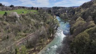 Korana Nehri 'nin insansız hava aracı manzarası Slunj yakınlarındaki engebeli arazide dönüyor. Ağaçlar kıştan dolayı hala çıplakken, berrak su ve yosunlu bankalar yaklaşan baharı ima ediyorlar. Hırvat doğası.