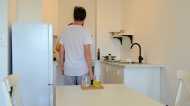 Genç çift, güzel ve rahat bir mutfakta ev yapımı öğle yemeği hazırlıyor. Sebze doğrarlar, yemek karıştırırlar, gülerler, yan yana yemek pişirmenin basit zevkini çıkarırlar. Paylaşılan işler bağlantı ve bakıma dönüşür.