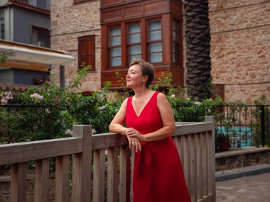 Sıcak yaz akşamları Antalya 'nın dar sokaklarında kırmızı elbiseli bir kadın yürüyor. Tarihsel atmosfer ve Akdeniz cazibesi barışçıl seyahat deneyimi yaratıyor.